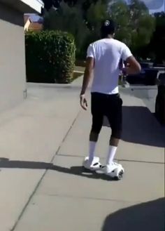 a man riding a skateboard down a sidewalk