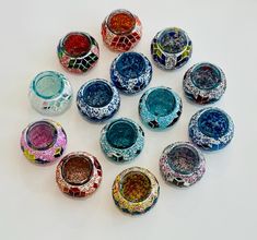 a group of colorful glass bowls sitting on top of a white table