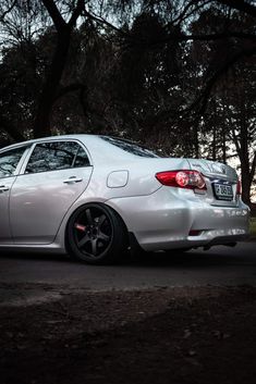 a white car parked in front of some trees