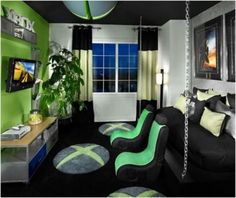 a living room with black and green furniture, rugs on the floor and pictures on the wall