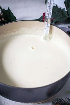 a large pan filled with liquid next to christmas greenery and a thermometer