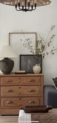 a living room with a couch, table and lamp hanging from it's ceiling