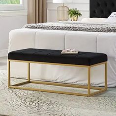 a black and gold bench in front of a white bed