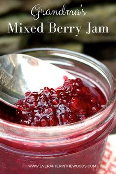 cranberry jam in a glass jar with a spoon on the side and text overlay that reads grandma's mixed berry jam