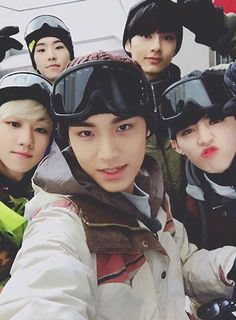 group of young men wearing ski goggles and snowboarding gear posing for the camera