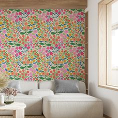 a white couch sitting in front of a colorful wallpaper on a living room wall