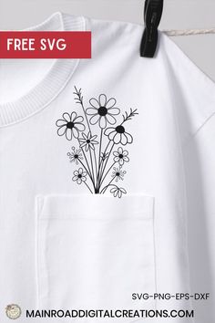 a white t - shirt with black and white flowers on it is hanging from a clothes line