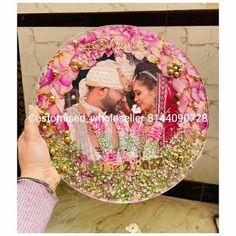 a man and woman are holding up a plate with flowers in the center on it