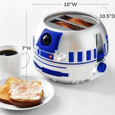 a toaster that is sitting on a plate next to a cup of coffee and some bread