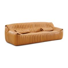 a tan leather couch with pillows on it's back and arm rests in front of a white background