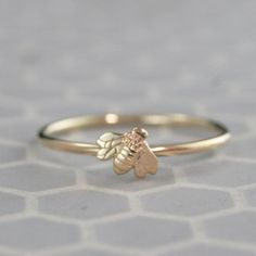 "Materials: 14K Gold (Your Choice of Color) Dimensions: Bee--7mm by 5.5mm; Band--1.25mm Full Round This is a perfect little stacking ring to add to any set, or wear it alone to show off your \"bee\" support. Hand crafted from solid 14K Gold, the band is made to size from 1.25mm (16 gauge) full round gold stock. A petite solid 14K Gold sculptural bee is securely soldered to the band to give it some character. Your ring will be given a meticulously hand polished finish. Blazer Arts is a family-own Bee Ring, Gold Stock, Jewelry Nature, Bee Jewelry, Gold Bee, Nature Ring, Save The Bees, Engraved Rings, Stacking Ring