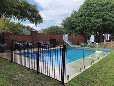 a fenced in swimming pool with a slide next to it