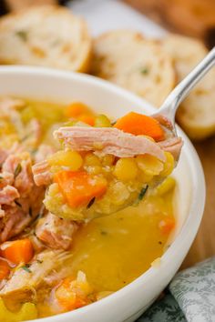 a spoonful of soup with ham and vegetables in it is being held by someone