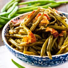 green beans with bacon in a blue and white bowl on a table next to green beans