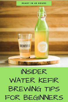 a bottle of beer sitting on top of a wooden table next to a glass filled with water