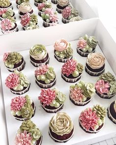 there are many cupcakes in the box with flowers on them