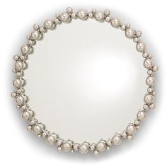 a round mirror with silver balls on the bottom and an oval frame in the middle