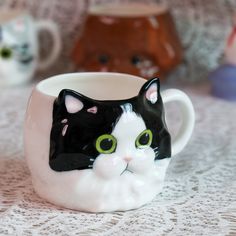 a black and white cat mug sitting on top of a table