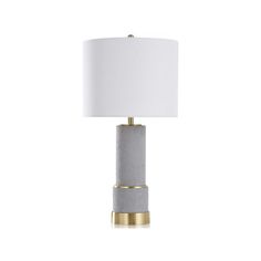 a table lamp with a white shade on the top and gold trimming around it