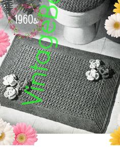 a crocheted rug with flowers on it and the words welcome home written in green