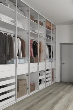 a walk - in closet with white walls and wooden floors