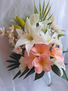 a bouquet of flowers sitting on top of a white tablecloth covered floor next to a wall