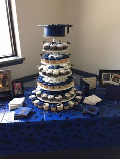 a table topped with cupcakes covered in frosting and blue icing next to a window