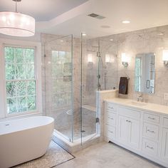 a bathroom with a tub, sink and large windows