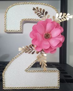 the number two is decorated with pink flowers and gold leaf accents on white acrylic