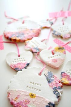 valentine's day ornaments made out of ceramic hearts and pink ribbon on a white table