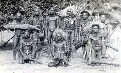 an old black and white photo of native american indians posing for a group photograph in front of trees