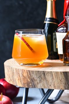 an apple cider sits next to bottles of wine