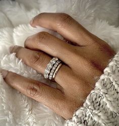 a woman's hand with two rings on top of her finger and the other ring is