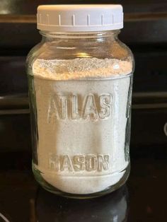 a glass jar filled with flour sitting on top of a counter