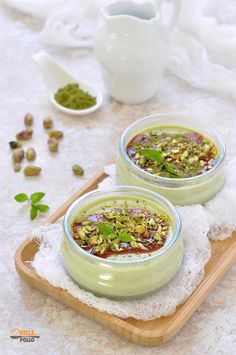 two bowls filled with soup sitting on top of a wooden tray