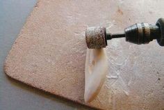 a piece of meat is being cut on a cutting board with an electric drill attached to it