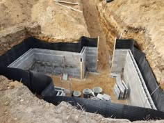 a construction site is being built on the side of a hill with concrete walls and pipes