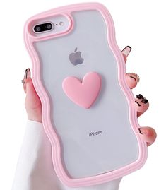 a woman holding an iphone case with a pink heart on the front and back cover