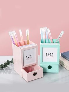 two boxes with toothbrushes in them sitting next to each other on a table