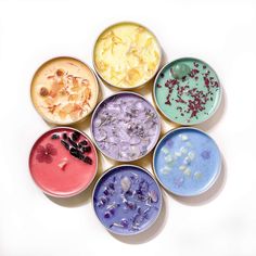 six small bowls with different types of food in them on a white surface, top view