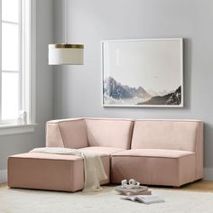 a living room with a pink couch and white rug