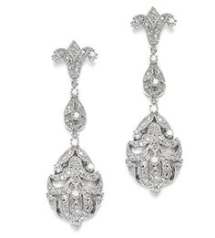 two pairs of earrings with diamonds on the bottom and one has a cross hanging from it