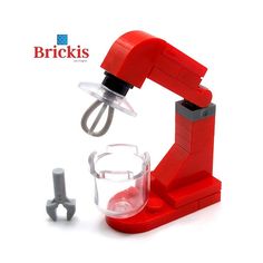 a red blender sitting on top of a white table next to a pair of scissors