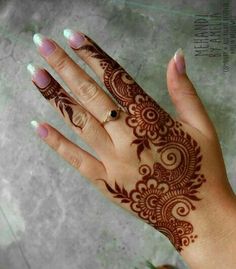 a woman's hand with henna tattoos on it