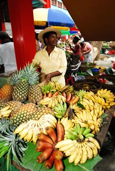 a man standing in front of a table filled with lots of fruit