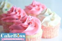 four cupcakes with pink frosting and sprinkles