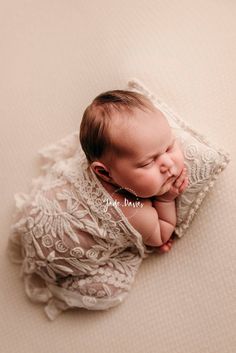 a baby wrapped in lace is laying down