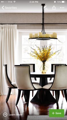 a dining room table with white chairs and a chandelier