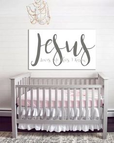 a baby's room with a crib and a sign that says jesus loves us