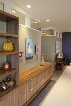 a living room filled with lots of furniture next to a wall covered in pictures and paintings